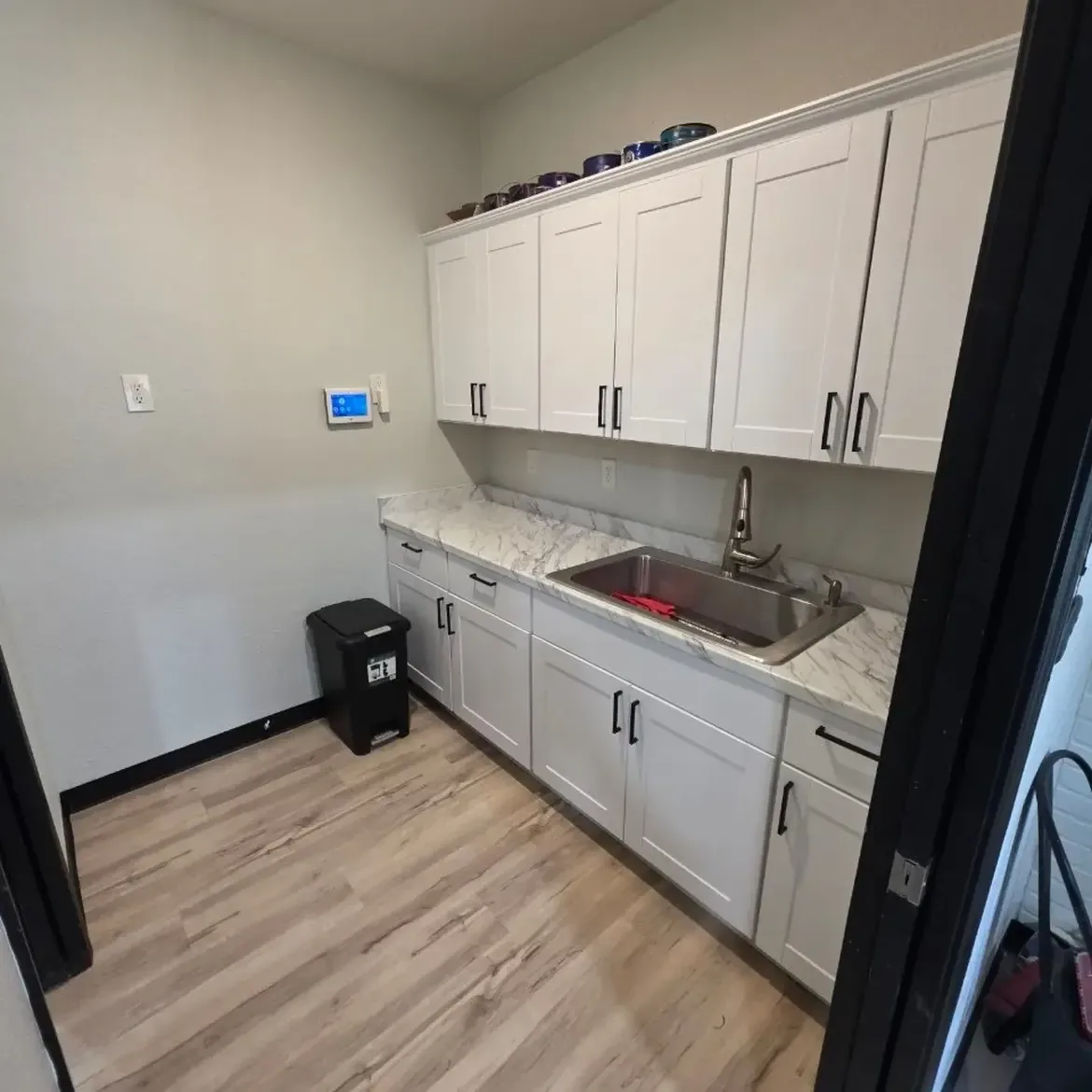 The same kitchen cleaned and repaired, with a clear floor and a finished ceiling